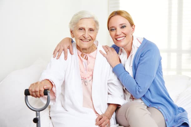 A caregiver hugging an elderly woman