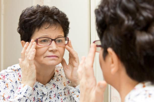 A woman adjusting her eyeglasses