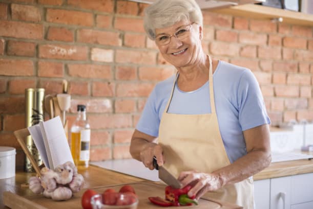 An old woman chopping peppers