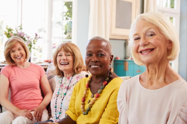 Four smiling women at a care home