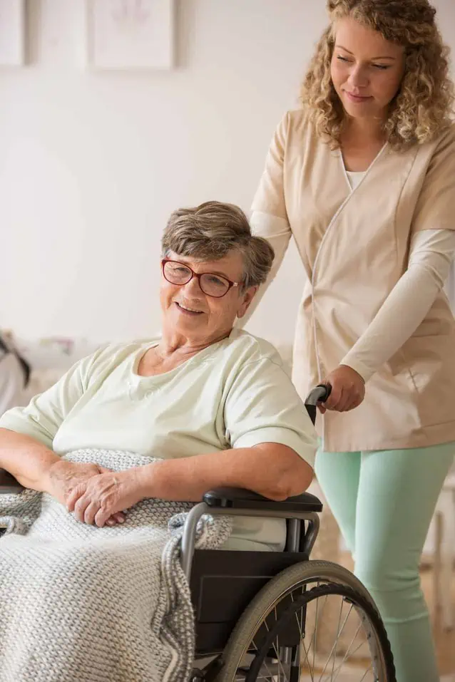 A caregiver pushing the wheelchair of a woman